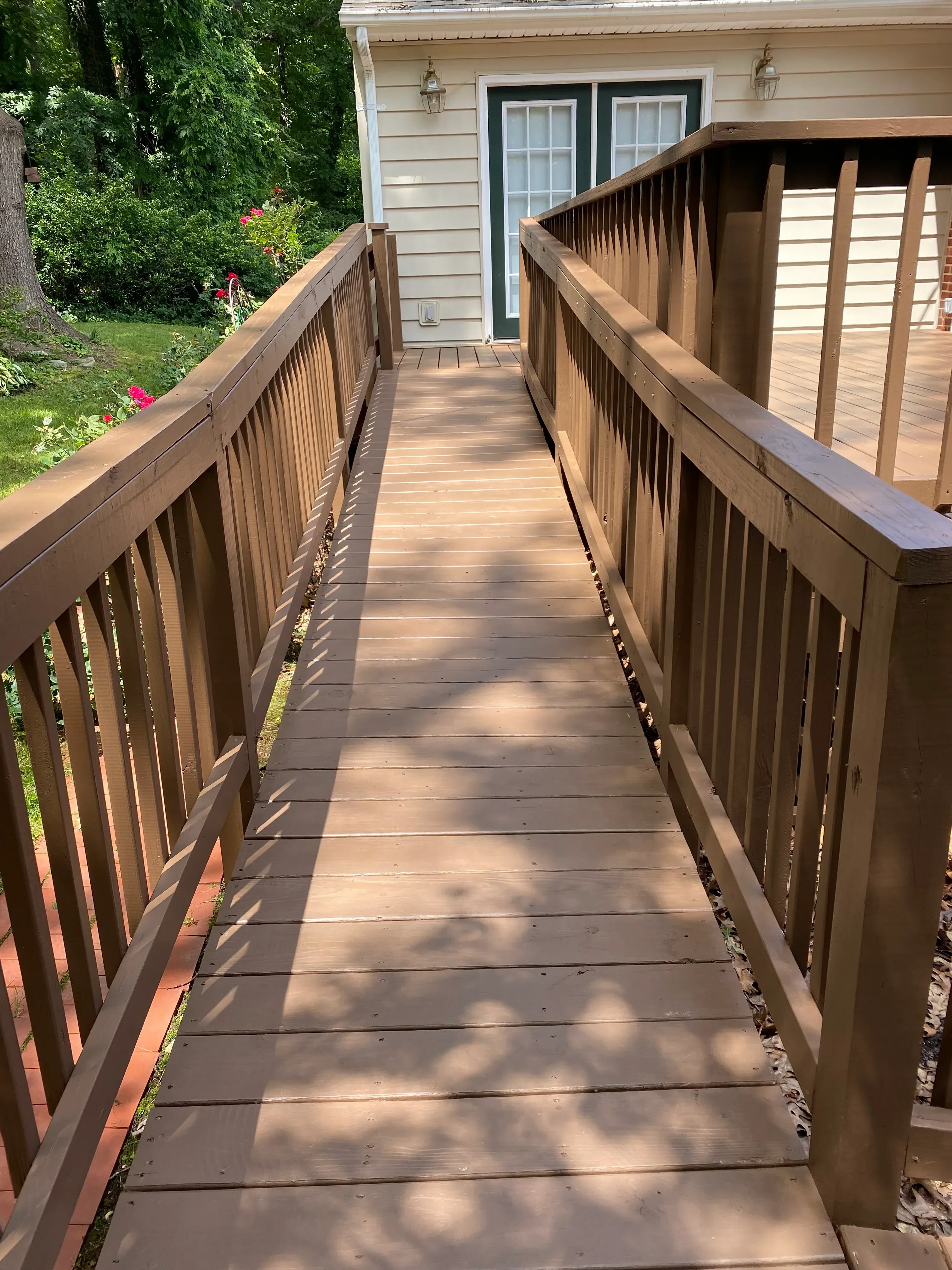 Stained composite deck with pergola overhead structure and protective finish